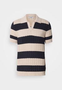 Pletené polo tričko s kr�átkým rukávem, představující střídavé béžové a námořnicky modré pruhy, výstřih do V a texturovanou látku s malými vzory děr.