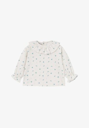 Blouse blanche à manches longues avec un col volé, ornée d'un motif de petits éléments bleus sur un fond clair.