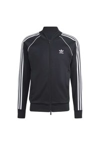 Svart zip-up sportjacka i slitstark tyg, med vita tre-randiga detaljer längs ärmarna och en liten logotyp på bröstet.