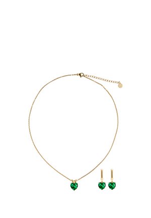 Collier en ton or avec un pendentif en cristal vert en forme de cœur ; boucles d'oreilles assorties en forme de cœur. Design de chaîne délicat avec fermoir ajustable.