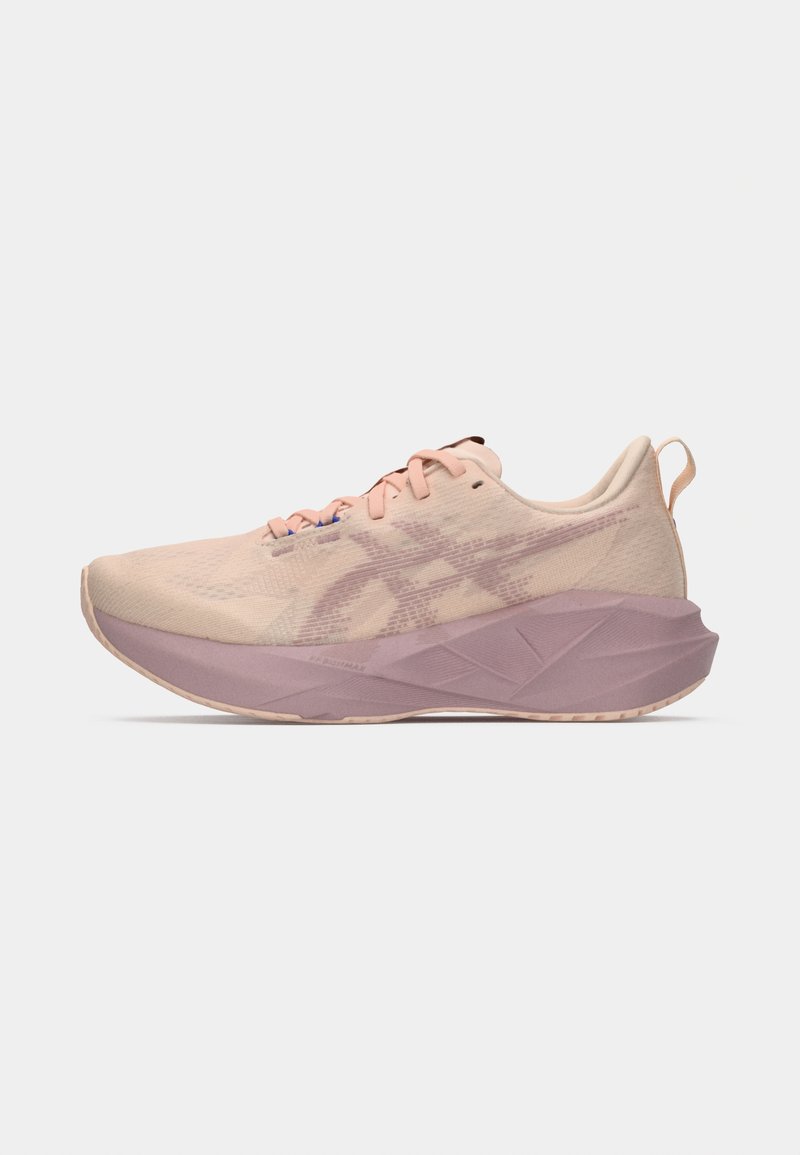 Baskets de course rose clair avec une tige en mesh, des accents texturés et une semelle intermédiaire violette. Présente des lacets plats et une languette au niveau du talon.