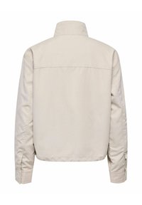 Veste beige légère à manches longues, col montant et poignets boutonnés, vue de dos sur fond blanc.