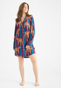 Knopen-nachtshirt in blauw en bordeaux met een tijgerprint. Lange mouwen, losse pasvorm en een borstzak. Soepele stoftextuur.