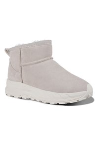 Beige ankelstøvle med en mokka-overflade, tekstureret overdel, hvidt faux fur-for og en robust hvid sål med et mønstret slidbane.