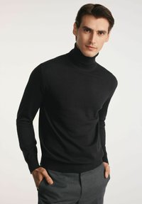 Czarny sweter z golfem wykonany z miękkiego materiału dziewiarskiego, z długimi rękawami. Charakteryzuje się dopasowanym krojem i subtelnym logo na klatce piersiowej.