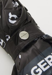 Black umbrella featuring a glossy coating, a compact design, and white logos. Accented with a silver button labeled "KARL LAGERFELD."