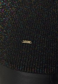 Czarny sweter prążkowany z wielokolorową metaliczną nitką, z małą złotą blaszką z logo na dolnej części przedniej strony. Miękka tekstura, dopasowany krój.