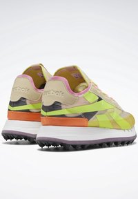 Baskets multicolores présentant un mélange de nuances jaunes, vertes et roses, avec une tige texturée, des semelles contrastées et un design volumineux.