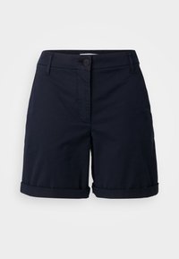 Námořnické modré bavlněné šortky s knoflíkovým zapínáním, přiléhavým pasem a ohrnutými lemy. Vyznačují se hladkým povrchem a minimalistickým designem.