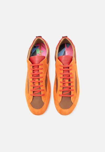 Ζευγάρι πορτοκαλί αθλητικά παπούτσια από σουέτ και δίχτυ με κόκκινες κορδόνια και πολύχρωμες, σχεδιασμένες ενσόλιδες, από πάνω σε λευκό φόντο.