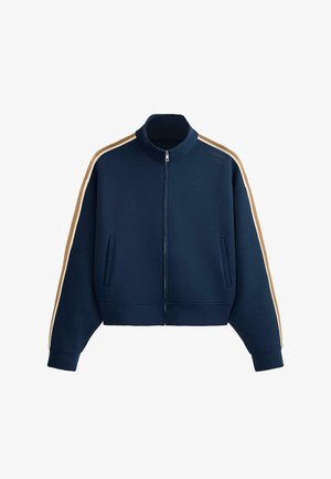 Navy blue zip-up jacket with high collar, side pockets, and beige and white stripes running down both sleeves.