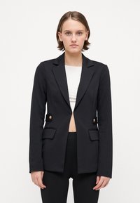 Čierny prispôsobený blazer s priliehavým strihom, dlhými rukávmi, dvoma prednými vreckami a zlatými gombíkmi. Hladká tkanina a štruktúrované klopy.
