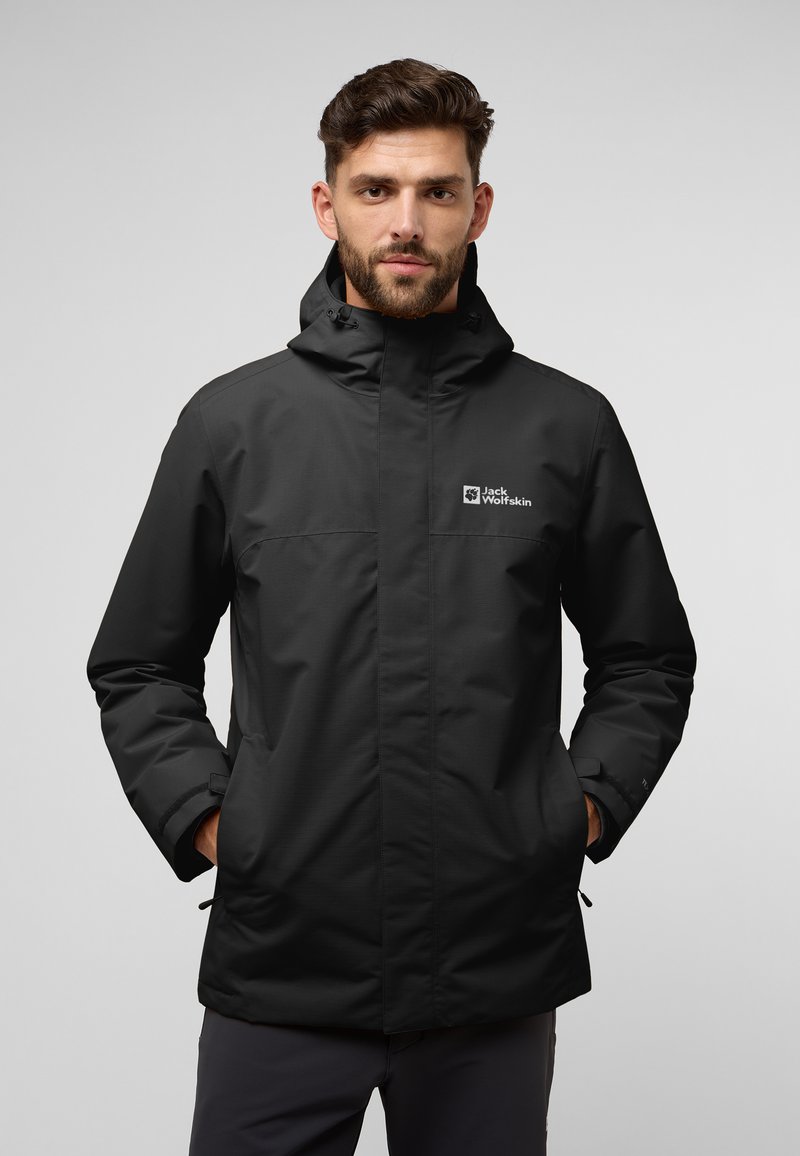 Zwarte waterdichte jas met capuchon, voorzien van een voorrits, twee zijzakken en het "Jack Wolfskin" logo op de borst.