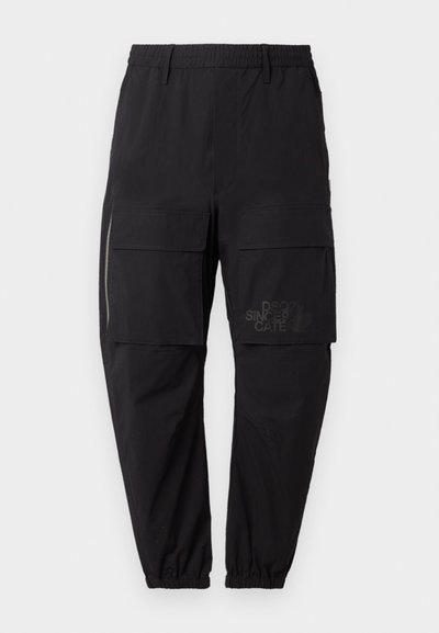 Black cargo pants with an elastic waistband, featuring multiple side pockets, a zipper detail, and a subtle printed logo on the thigh.