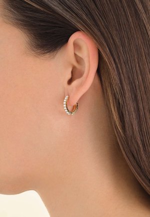 Boucles d'oreilles en métal doré avec des pierres transparentes, au design en spirale texturé. Les boucles sont petites et épousent étroitement le lobe de l'oreille.