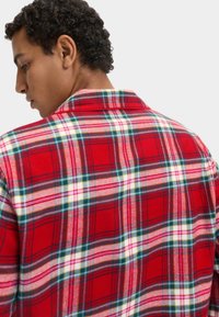 Czerwona koszula flanelowa w kratę z białymi, zielonymi i różowymi akcentami. Miękka w dotyku, z kołnierzykiem.