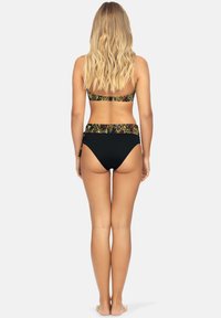 Czarny bikini z paskami w kwiatowy wzór. Majtki ze wysokim stanem i wiązaniem z boku. Gładki, elastyczny materiał.