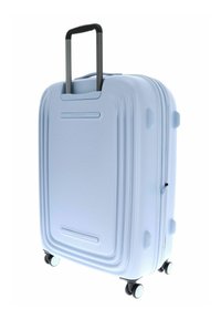 Valigia rigida di colore azzurro chiaro con superficie testurizzata, manico retrattile e quattro ruote per una facile mobilità. Presenta una chiusura a cerniera.