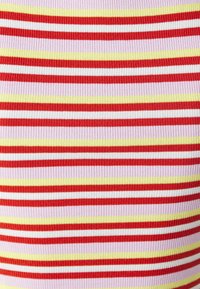 Tissu côtelé avec des rayures alternées de rouge, blanc, jaune et rose pâle, présentant une texture fine et un motif cohérent sur l'ensemble.