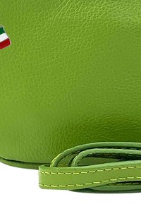 Groene leren tas met een gestructureerde afwerking, voorzien van een groene schouderband en gele stiksels, versierd met een klein Italiaans vlagdetail.