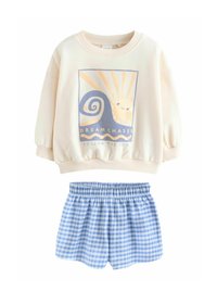 Felpa in cotone color bianco sporco con stampa grafica che rappresenta un sole e onde; abbinata a pantaloni corti in gingham blu con cintura elastica.