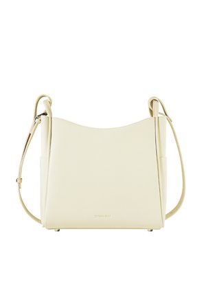 Borsa a tracolla in pelle color crema con parte superiore curva, tracolla regolabile e design minimalista. Presenta un logo sulla parte anteriore.