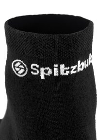 Schwarze Socke mit einem strukturierten Muster, ausgestattet mit einem weißen gestickten Logo "Spitzbuk" auf der Oberseite. Glattes Material, in mittlerer Wadenhöhe.