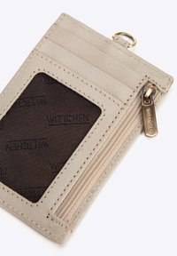 Portafoglio in pelle grigia con due slot per carte, una finestra trasparente per l'ID e un compartimento con zip, dotato di un tirazip in tono oro.