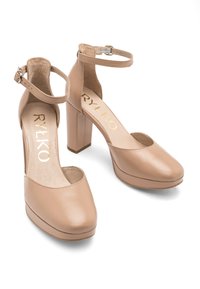 Beżowe buty na wysokim obcasie z paskiem wokół kostki i okrągłym noskiem, wykonane z gładkiej skóry, z blokowym obcasem i podeszwą platformową.