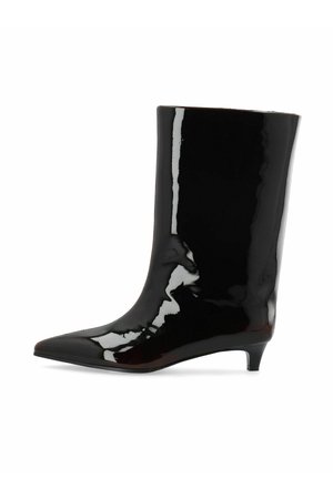 Botte mi-mollet en cuir verni noir avec bout pointu et petit talon kitten, montrée de profil sur fond blanc.