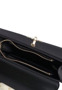 Borsa a tracolla in pelle nera con texture, dotata di una chiusura e una cerniera in finitura dorata, caratterizzata da un ampio interno e dettagli hardware decorativi.