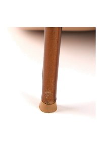 Une seule patte de chaise en métal marron avec une pointe en caoutchouc beige reposant sur une surface blanche.