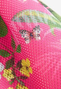 Buntes pinkes Gewebe mit einem strukturierten Mesh-Muster, das lebhafte grüne Blätter und ein Schmetterlingsdesign zwischen gelben Blumen zeigt.