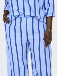 Svijetloplave hlače širokog kroja s vertikalnim tamnoplavim prugama, s opuštenim krojem i bočnim džepovima, izrađene od mekog materijala.