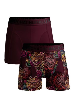 Dve moški bokser hlačke, ene v enobarvni temno bordo barvi in druge z barvitimi vzorci rjovečega tigra in cvetja, obe s črnima pasovoma z napisom "Muchacho Malo".