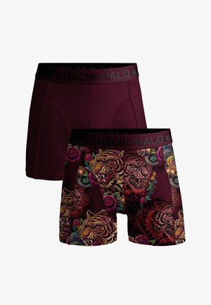 Dva páry pánskych boxeriek, jeden jednoliate tmavý bordový a druhý s farebnými vzormi burácajúceho tigra a kvetov, oba s čiernymi pásmi na páse s nápisom "Muchacho Malo".