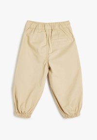 Beige bukser med elastisk talje og afslappet pasform, med samlede manchetter og en baglomme. Fremstillet af letvægtsstof med glat overflade.