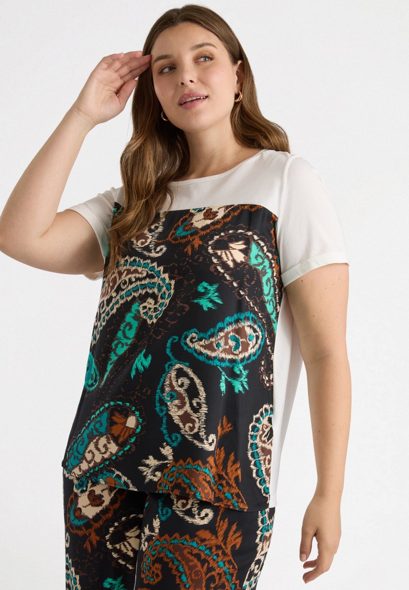 Top de manga corta con una sección superior color crema y una sección inferior negra, adornada con intrincados patrones paisley en tonos verde azulado, marrón y beige.