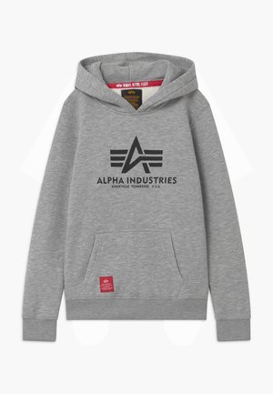 Sweat à capuche gris avec une poche avant, arborant un logo noir et le texte "ALPHA INDUSTRIES" imprimé sur la poitrine, ainsi qu'une étiquette rouge sur la poche.