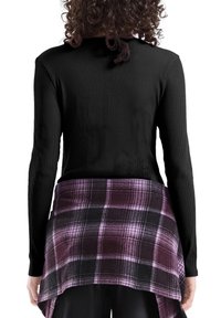 Czarny prążkowany top z długim rękawem z fioletowo-czarną kratowaną warstwą koszuli pod spodem, charakteryzujący się miękką teksturą i warstwowym krojem.
