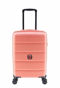 Valise rigide de couleur corail, avec une surface texturée à lignes horizontales, une fermeture éclair centrale et une poignée noire rétractable. Quatre roues.