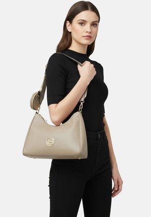 Borsa sintetica beige con forma curva e dettaglio logo dorato. Presenta una tracolla removibile e una tasca esterna con cerniera per comodità.