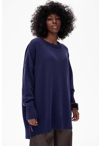 Marineblauwe oversized trui met een geribbelde zoom en manchetten. Gemaakt van een gestructureerde stof, met een ronde halslijn en brede mouwen.