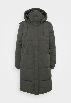 Lange, gevoerde pufferjas met capuchon in donker groen. Bevat doorstikte secties, verstelbare trekkoorden en zijzakken. Gemaakt van waterafstotend materiaal.