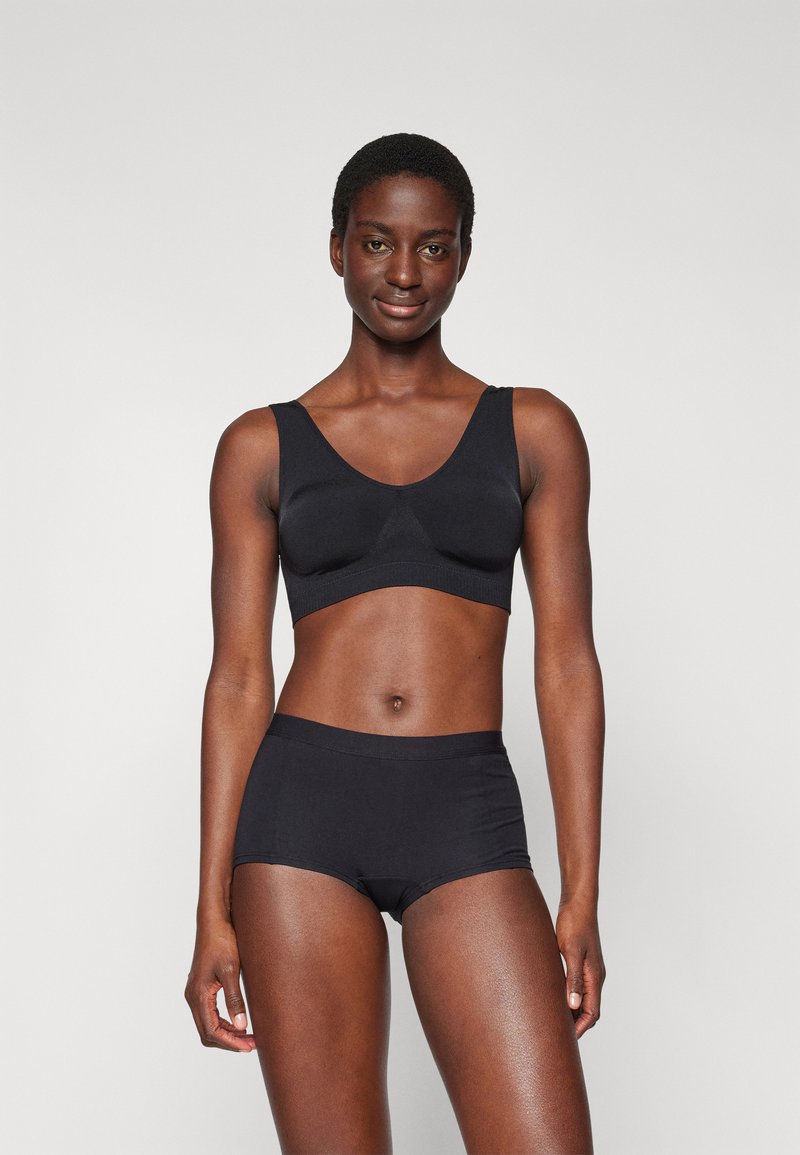 Black seamless bralette with wide straps and a soft texture, paired with matching black hipster briefs. Simple, functional design.