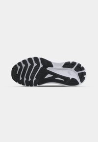 Sorte svart-hvitt sneakersåle har en teksturert gummioverflate, mønstrede spor for grep, og et buet design for fleksibilitet.