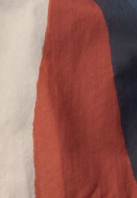 Stoff mit horizontalen Streifen in Creme, Rost und Marineblau, mit einer glatten Textur und subtilen Farbverläufen.