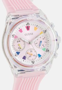 Rosa Silikonarmbanduhr mit einem transparenten Gehäuse, ausgestattet mit einem pastellrosa Ziffernblatt, farbigen Stundenmarkierungen und drei Unterziffernblättern in kontrastierenden Farben.