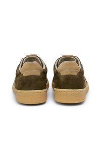 Zielone zamszowe trampki z beżowymi akcentami, okrągłym tyłem, teksturowanymi podeszwami i przeszyciami. Płaskie sznurowadła i wyściełane kołnierze.
