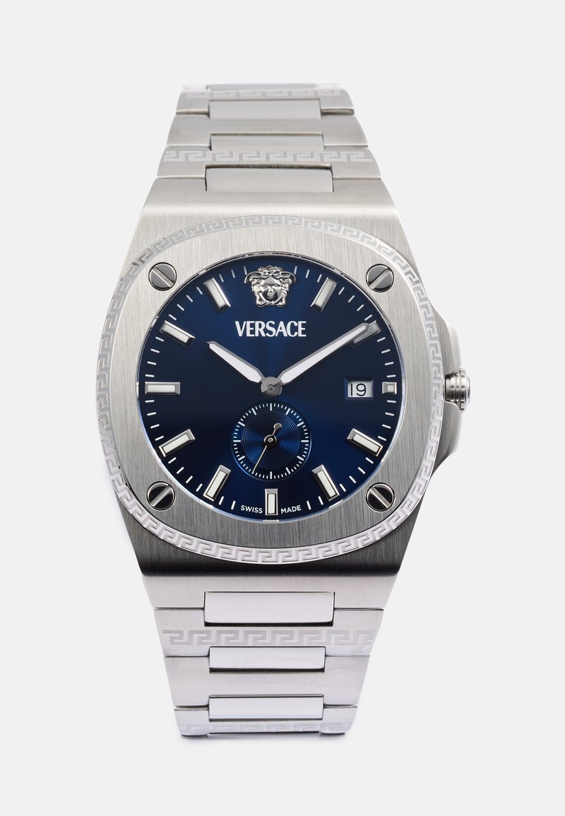 Strieborné hodinky Versace zo nehrdzavejúcej ocele s modrým ciferníkom, emblémom leva, oknom na dátum a vzorovaným remienkom s dizajnom gréckeho kľúča.